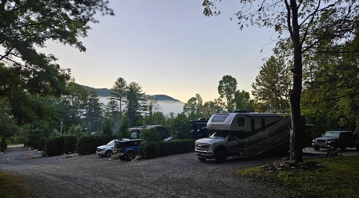 Class A motorhome on a gravel site with morning fog in the valley